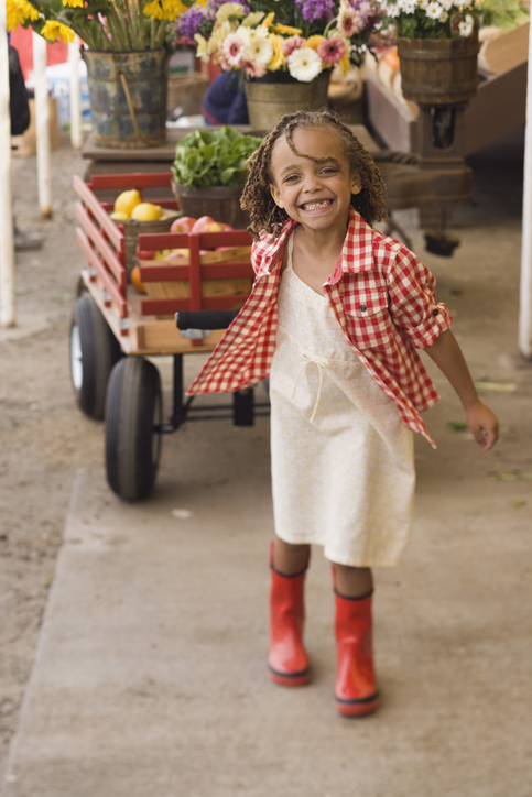 Mädchen mit Bollerwagen auf dem Bauernmarkt