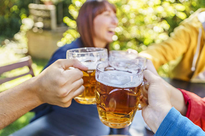 Bierkrüge werden angestoßen von einigen Menschen