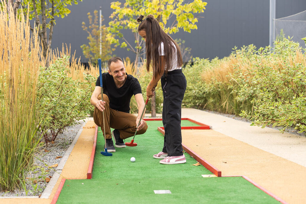 Ein Vater lernt seiner Tochter Minigolf