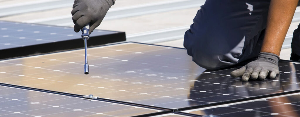 Handwerker befestigt mit Schraubenschlüssel Solarpanelle (Ausschnitt)