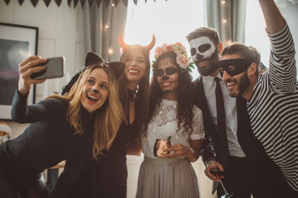 Junge maskierte Partygäste machen ein Selfie
